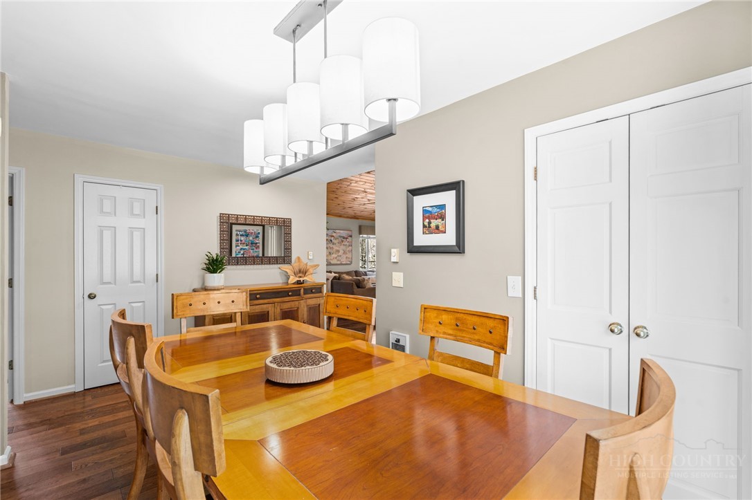220 Woodwinds Lane Seven Devils, NC 28604 - Photo 23 of 46 a view of a dining room with furniture a chandelier and wooden floor