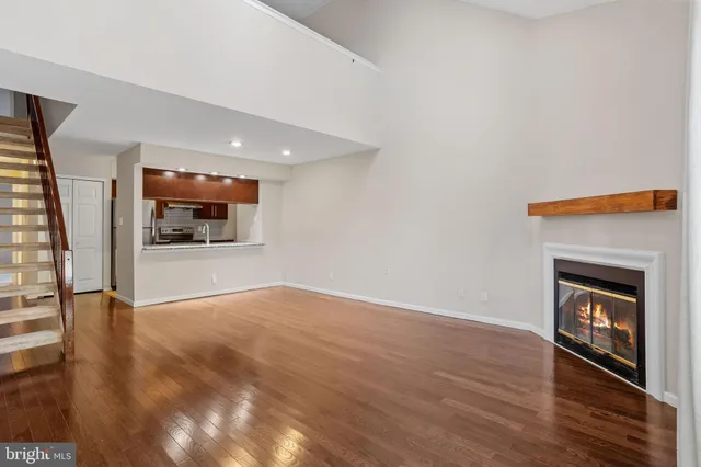a view of an empty room with a fireplace and wooden floor
