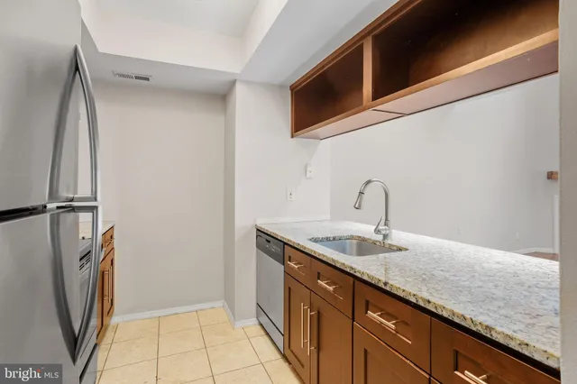 a kitchen with stainless steel appliances granite countertop a sink and a refrigerator