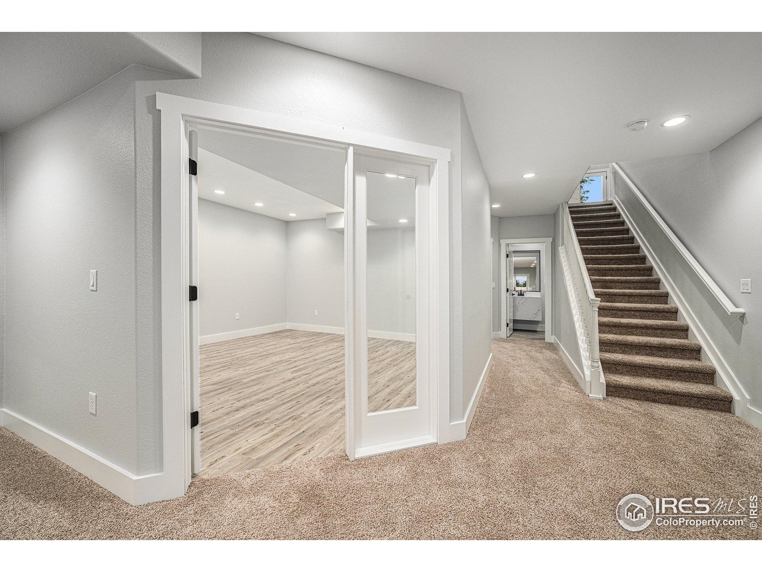 796 Abrams Way Berthoud, CO 80513 - Photo 16 of 40 a view of a hallway with wooden floor and staircase
