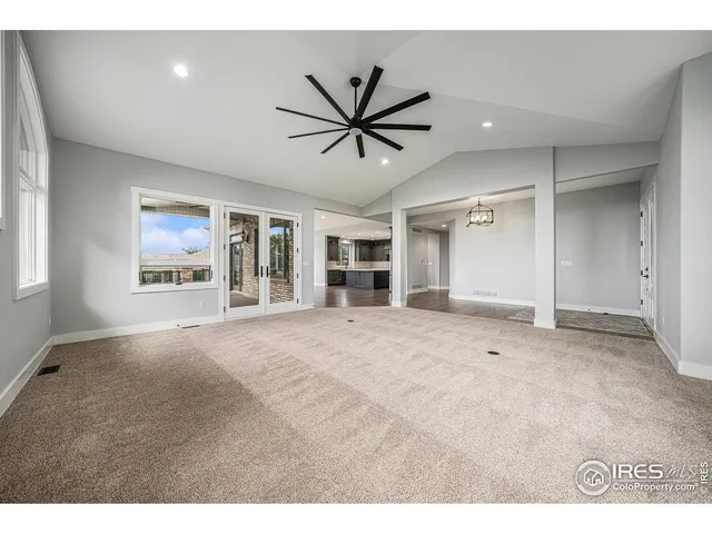 a view of a livingroom with a chandelier fan and windows