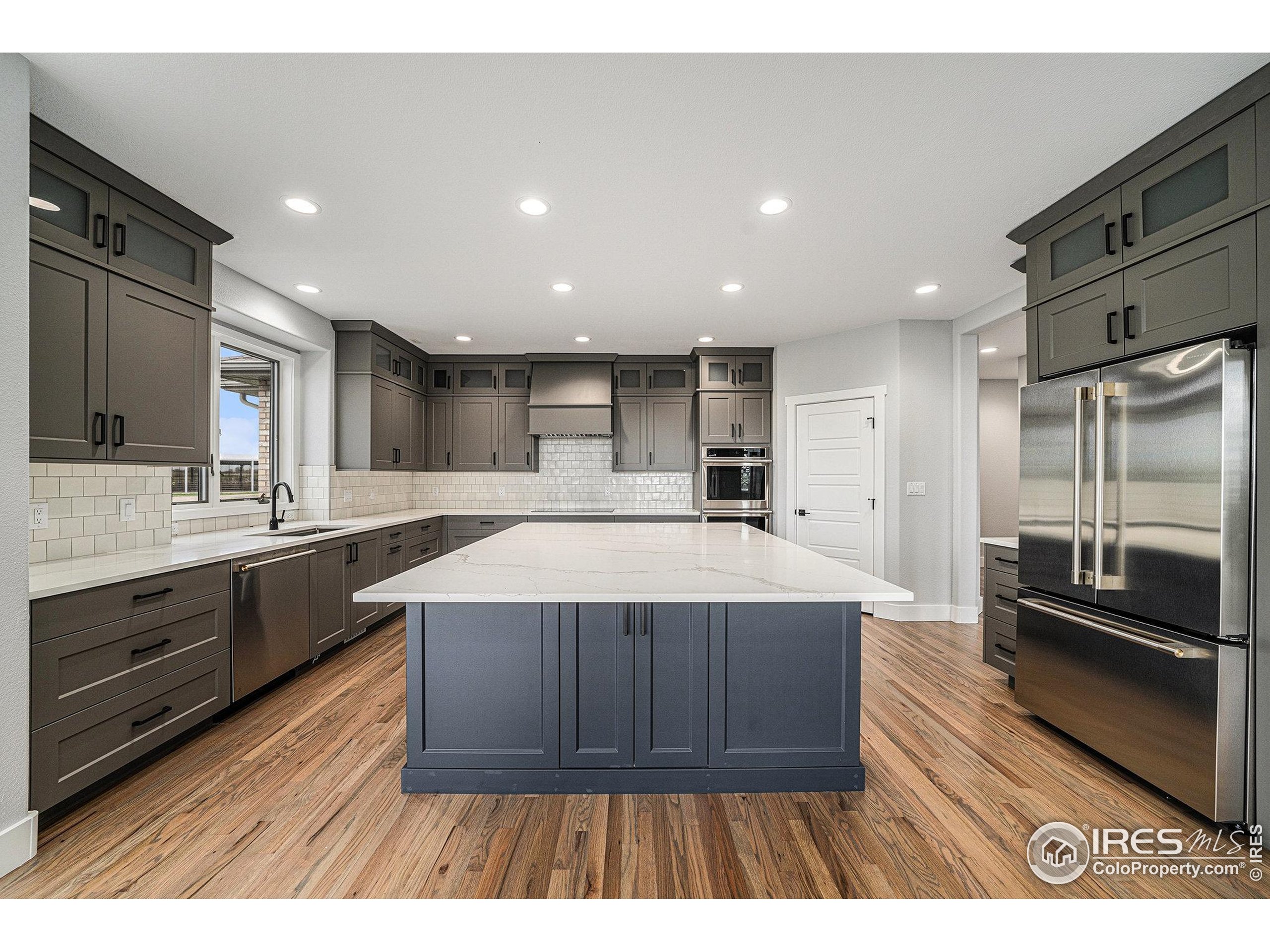 796 Abrams Way Berthoud, CO 80513 - Photo 7 of 40 a large kitchen with stainless steel appliances a large counter top a sink and a refrigerator