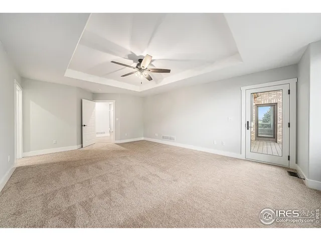 a view of an empty room with a chandelier fan