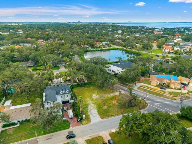 an aerial view of residential houses with outdoor space and trees