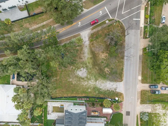 an aerial view of residential houses with outdoor space and trees