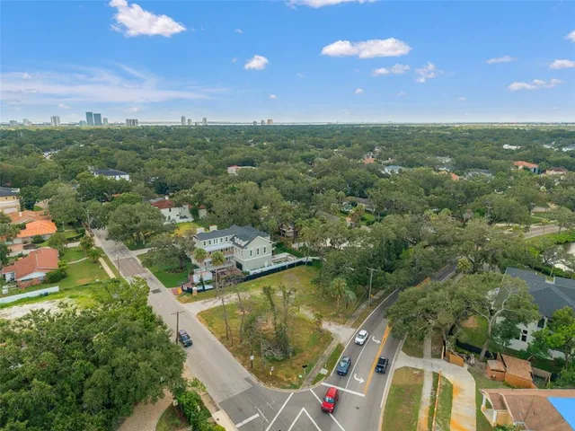 an aerial view of residential houses with outdoor space and trees