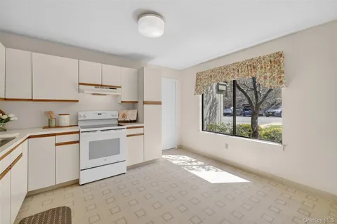 a kitchen with granite countertop white cabinets and white appliances