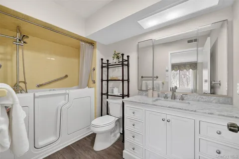 a bathroom with a granite countertop sink toilet and shower