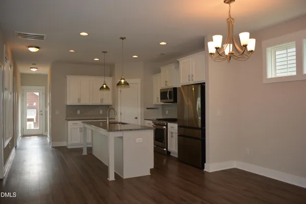 a kitchen with stainless steel appliances granite countertop a sink a stove and a refrigerator