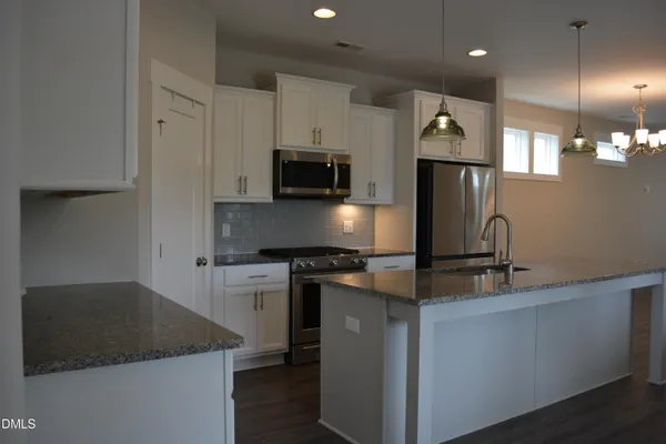 a kitchen with stainless steel appliances granite countertop a sink a stove and a microwave