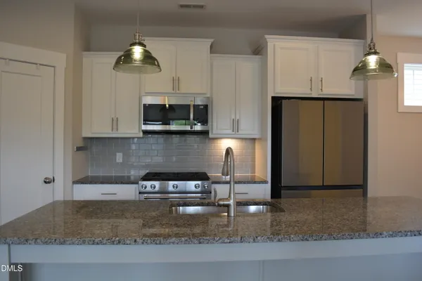 a kitchen with stainless steel appliances granite countertop a sink stove and cabinets