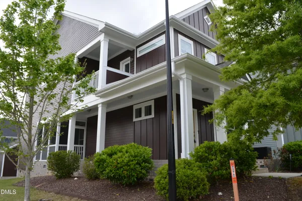 a front view of a house with plants and trees