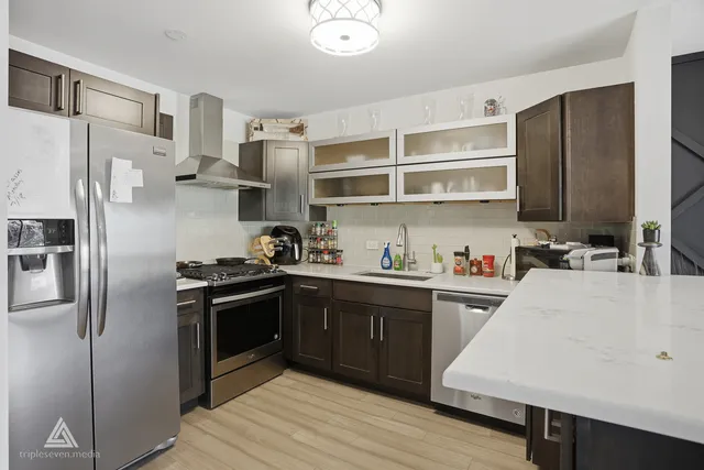 a kitchen with stainless steel appliances a stove a sink and refrigerator