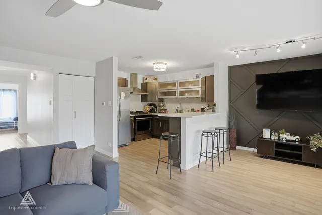a living room kitchen with furniture and a flat screen tv