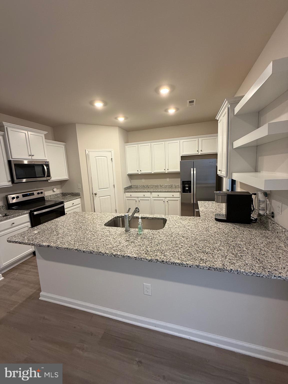 17305 George Ruffin Road Milford, VA 22514 - Photo 3 of 6 a kitchen with stainless steel appliances granite countertop a sink stove and a granite counter tops