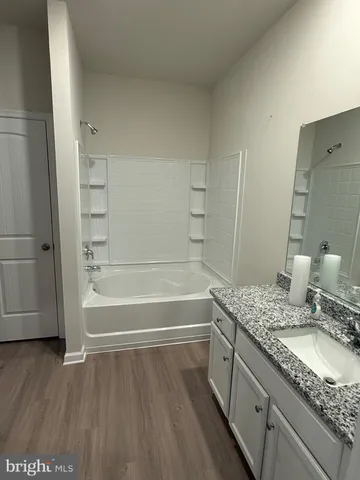 a bathroom with a granite countertop sink a toilet and bathtub