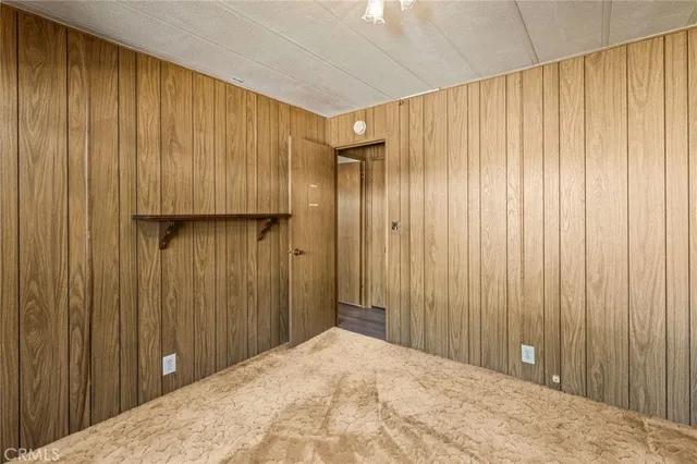 an empty room with wooden floor cabinet and windows