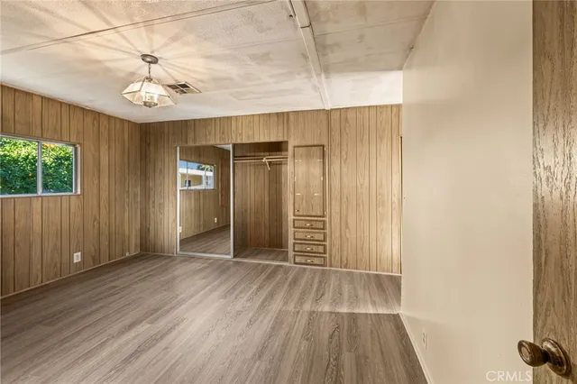 a view of a hallway with wooden floor and cabinet