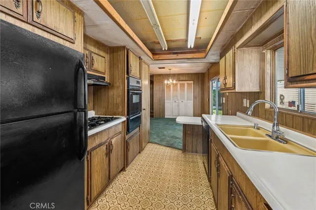 a kitchen with stainless steel appliances granite countertop a sink and a refrigerator