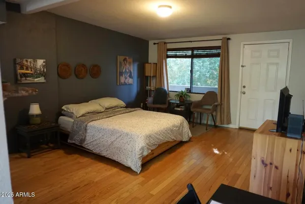 a bedroom with a bed and wooden floor