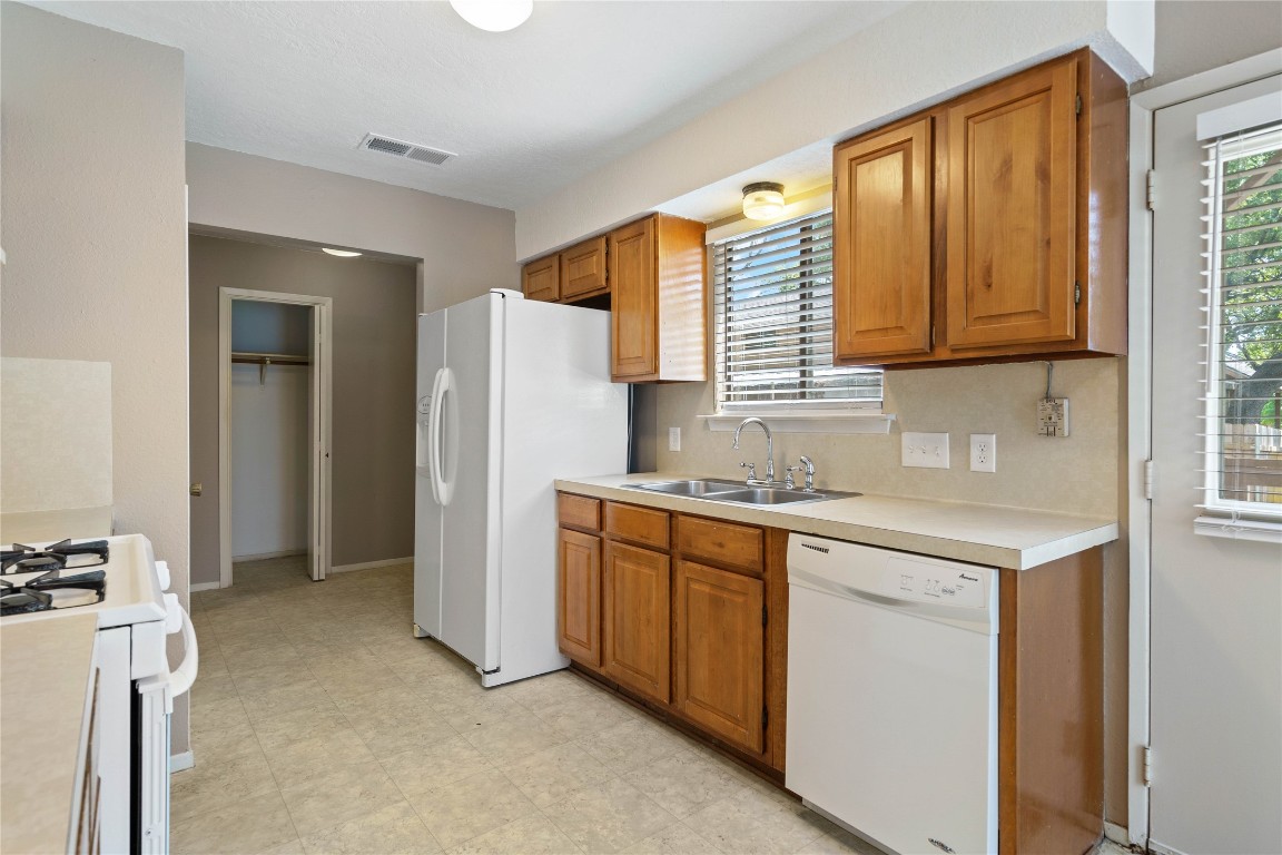 8005 Hood Circle, Unit B Austin, TX 78745 - Photo 6 of 18 a kitchen with a sink cabinets and a refrigerator