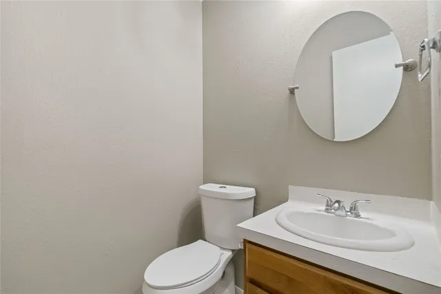 a bathroom with a toilet a sink and mirror
