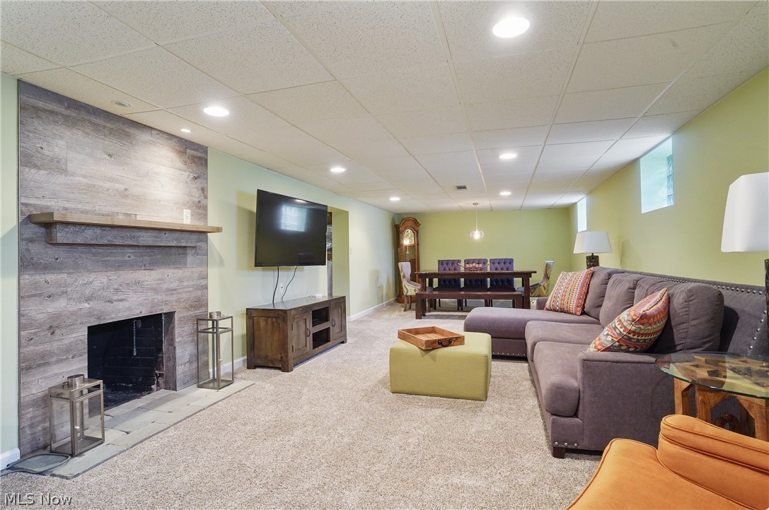 1150 Garman Road Akron, OH 44313 - Photo 27 of 38 Carpeted living room featuring a tiled fireplace and a paneled ceiling