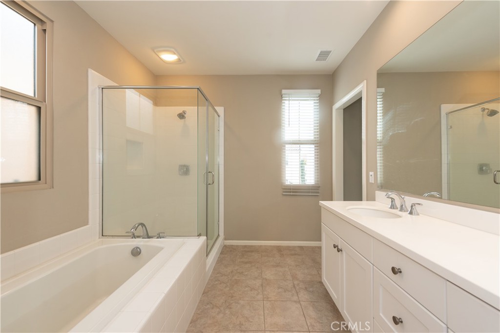 107 Desert Lotus Irvine, CA 92618 - Photo 11 of 21 a bathroom with a double vanity sink large mirror and a bathtub