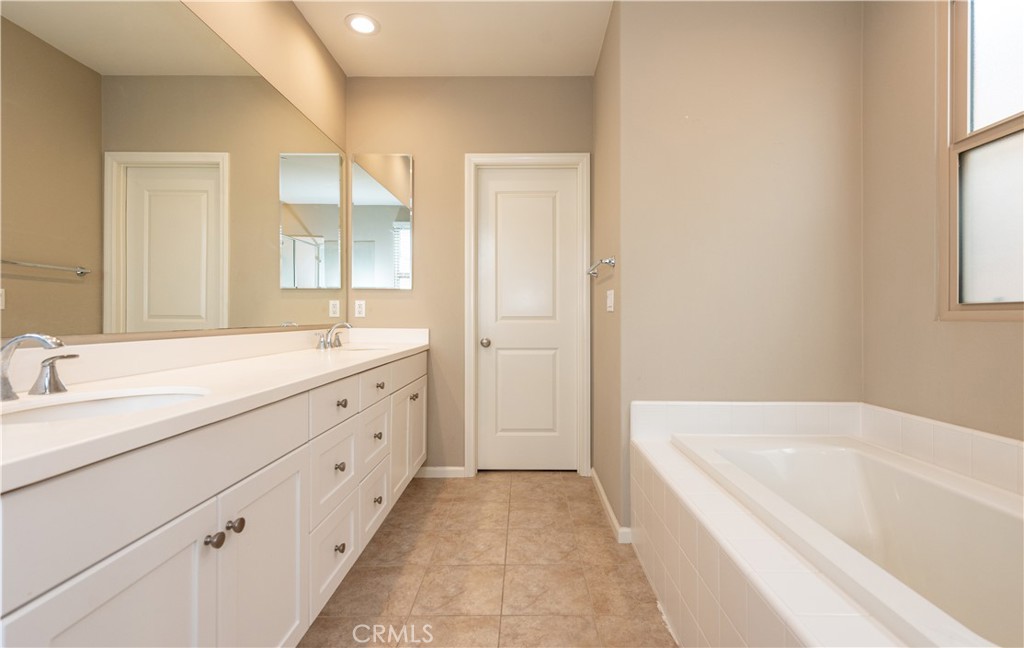 107 Desert Lotus Irvine, CA 92618 - Photo 12 of 21 a spacious bathroom with a tub sink and mirror