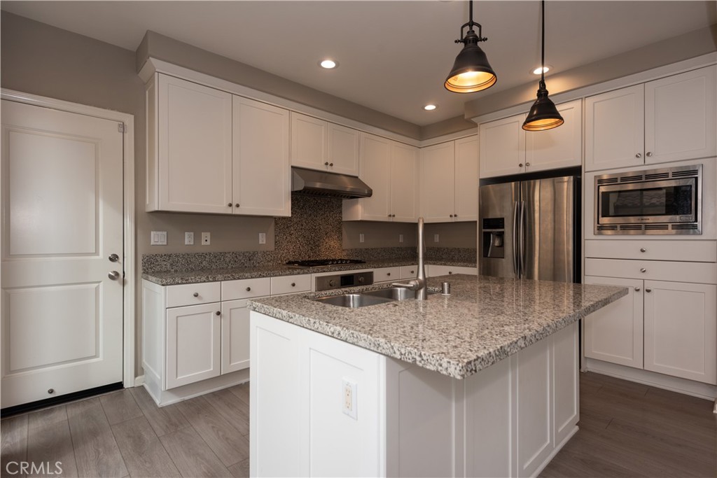 107 Desert Lotus Irvine, CA 92618 - Photo 4 of 21 a kitchen with stainless steel appliances granite countertop a sink refrigerator and cabinets