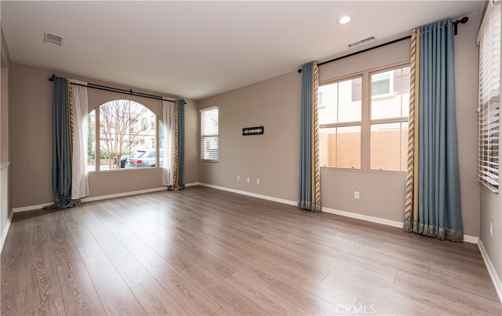 107 Desert Lotus Irvine, CA 92618 - Photo 6 of 21 an empty room with wooden floor and windows