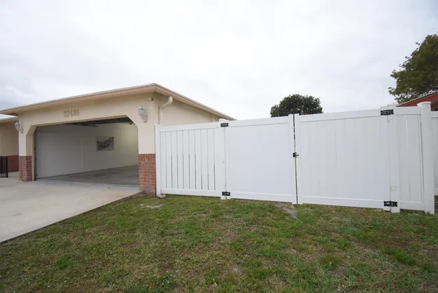 a backyard of a house with plants and wooden fence