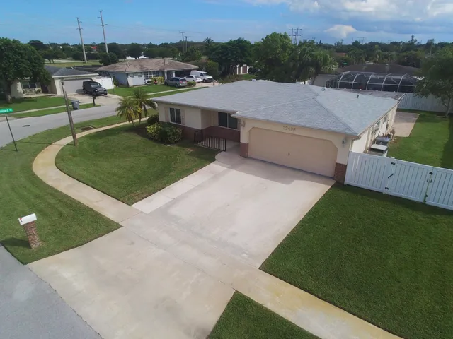 an aerial view of a house with swimming pool garden and patio