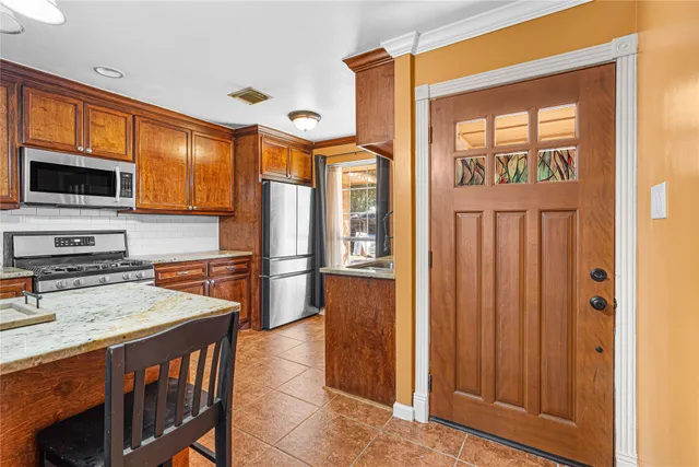 a kitchen with stainless steel appliances granite countertop a refrigerator and a stove top oven