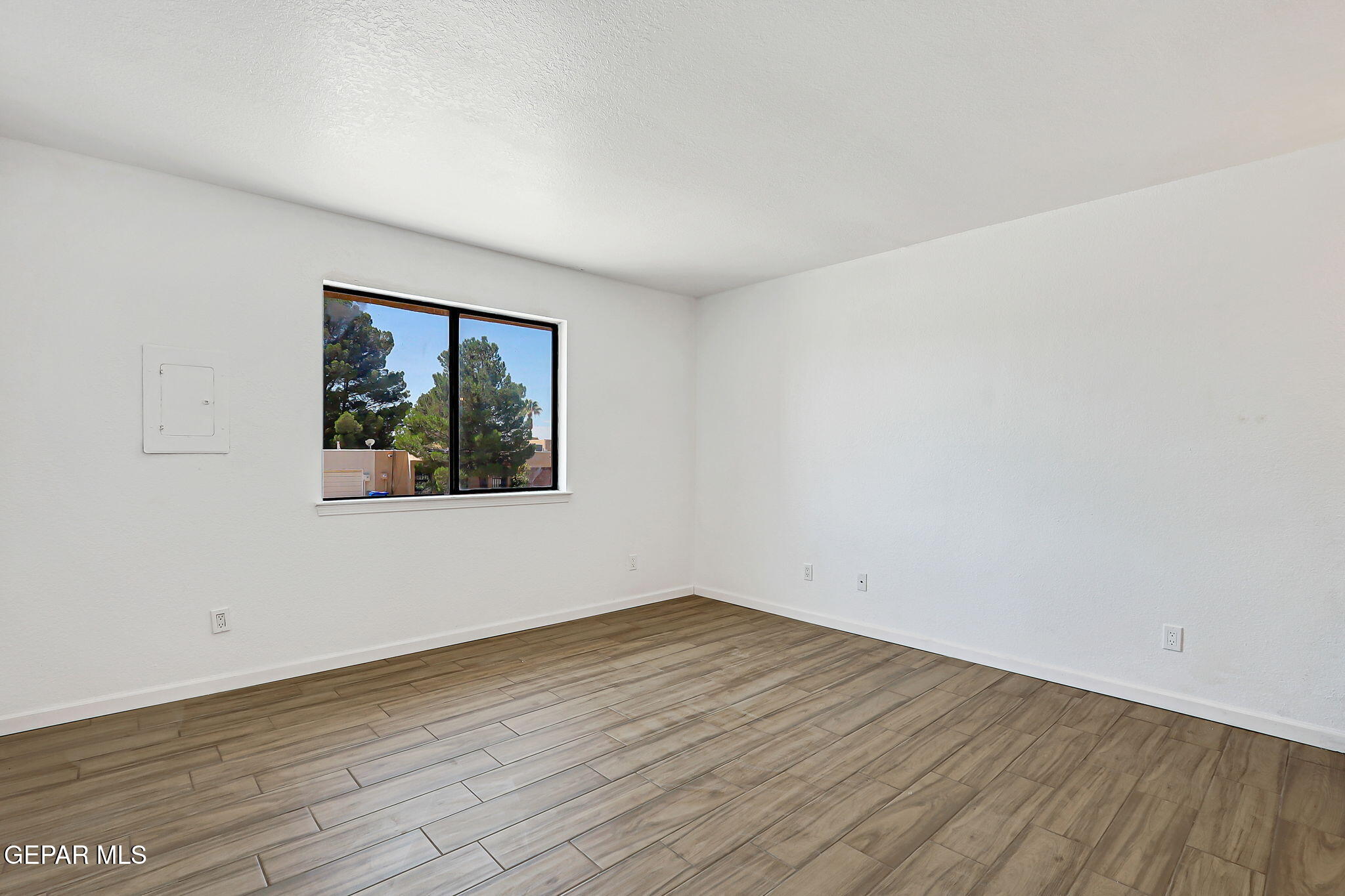 1053 Hillrise Court Las Cruces, NM 88011 - Photo 21 of 53 an empty room with wooden floor and window