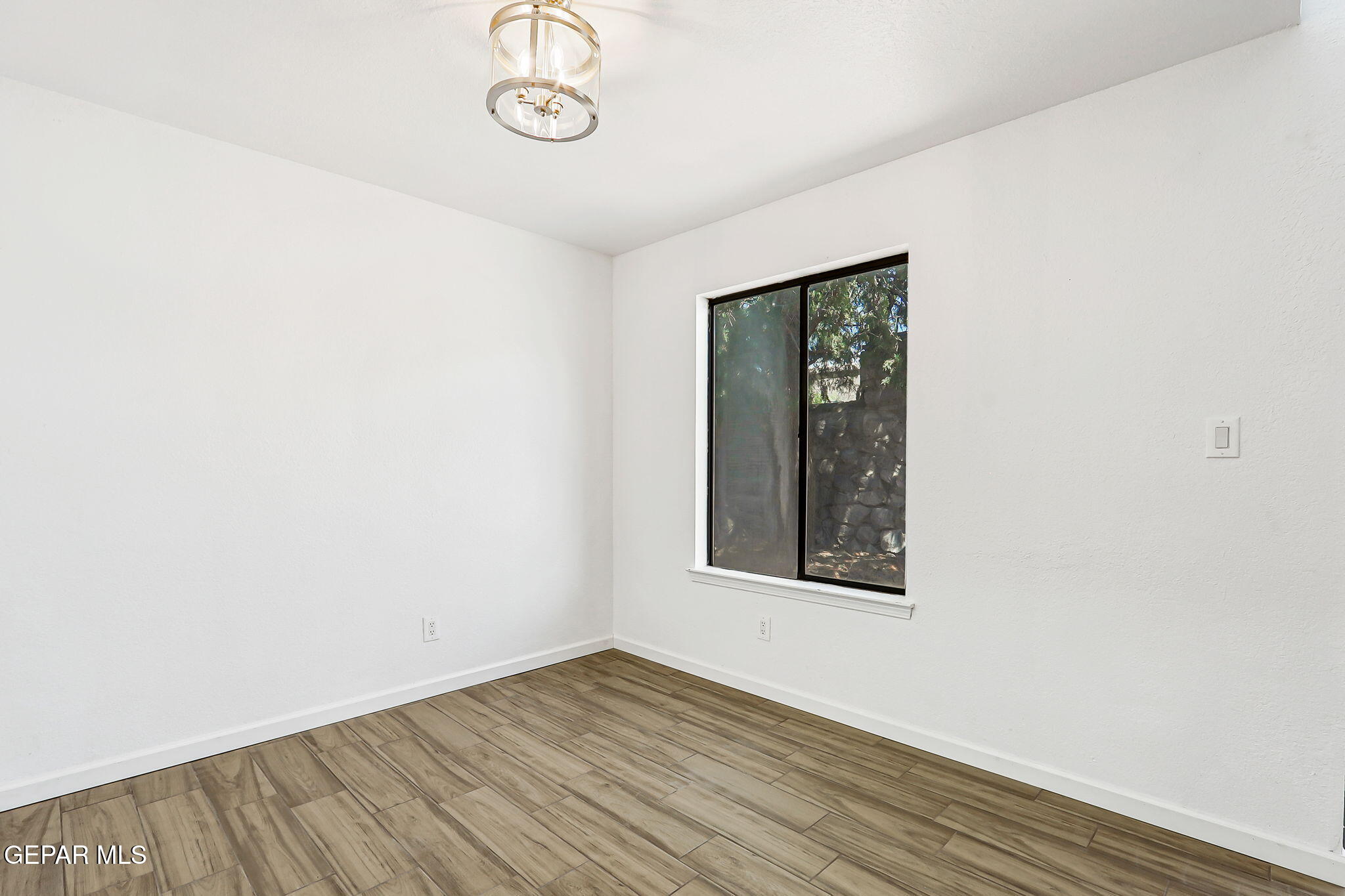 1053 Hillrise Court Las Cruces, NM 88011 - Photo 31 of 53 an empty room with wooden floor and windows