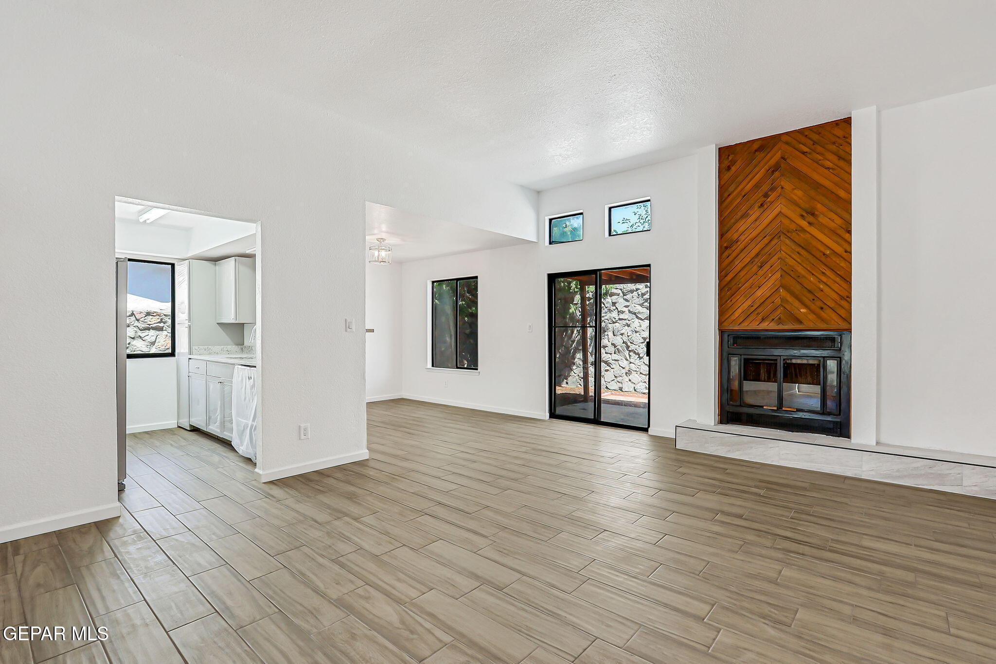 1053 Hillrise Court Las Cruces, NM 88011 - Photo 38 of 53 an empty room with wooden floor fireplace and windows