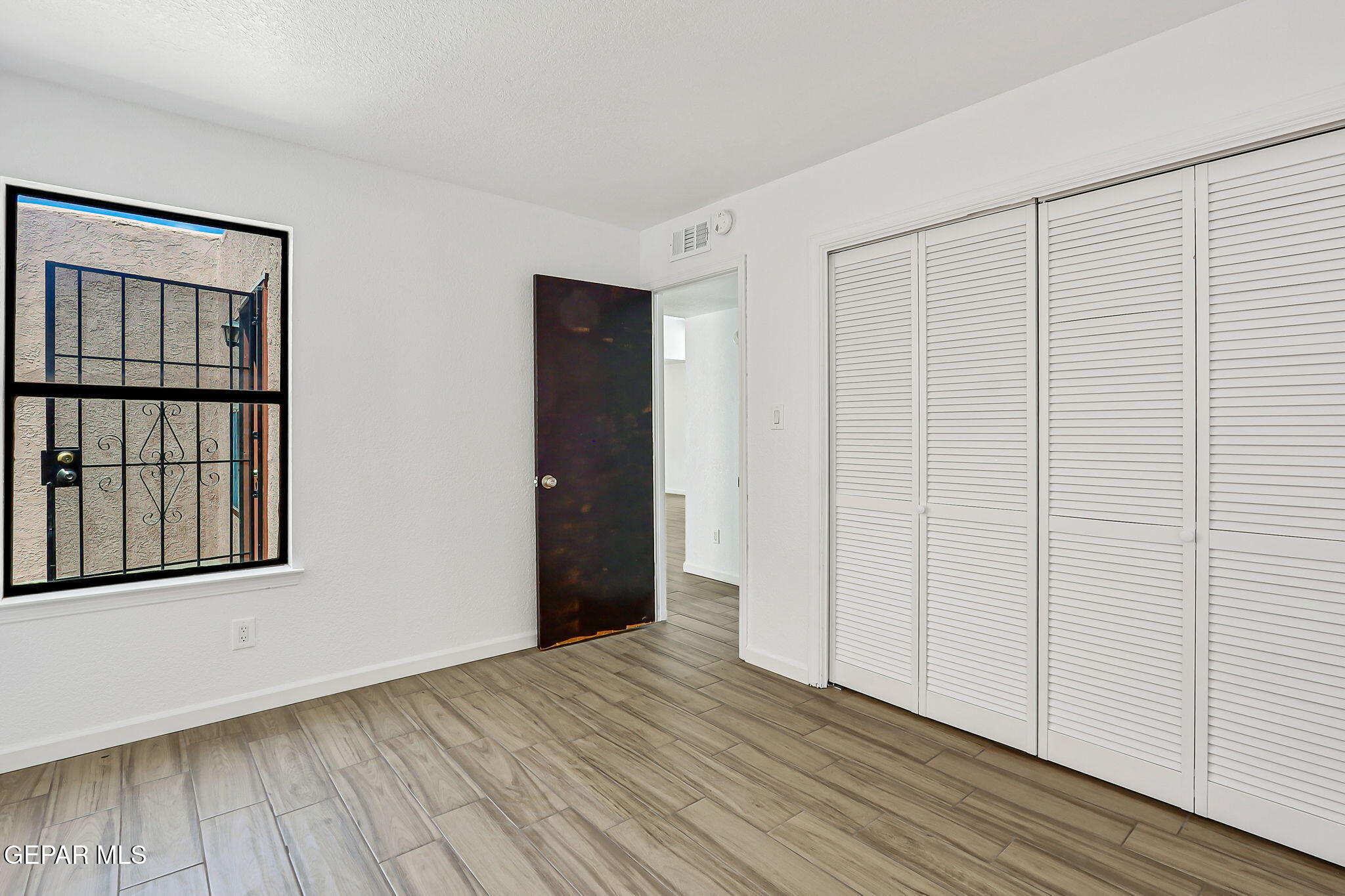 1053 Hillrise Court Las Cruces, NM 88011 - Photo 42 of 53 an empty room with wooden floor and windows