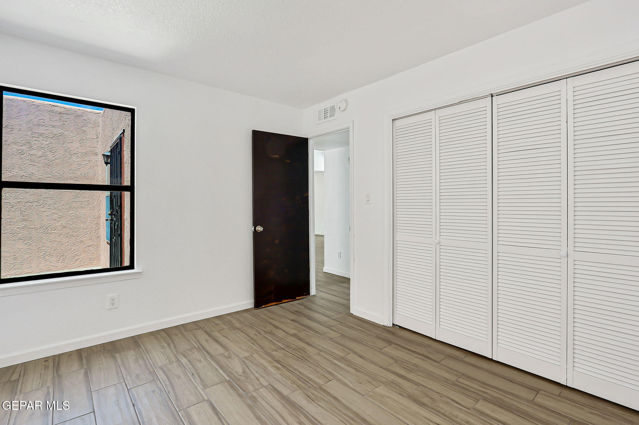 1053 Hillrise Court Las Cruces, NM 88011 - Photo 43 of 53 a view of an empty room with wooden floor and a window