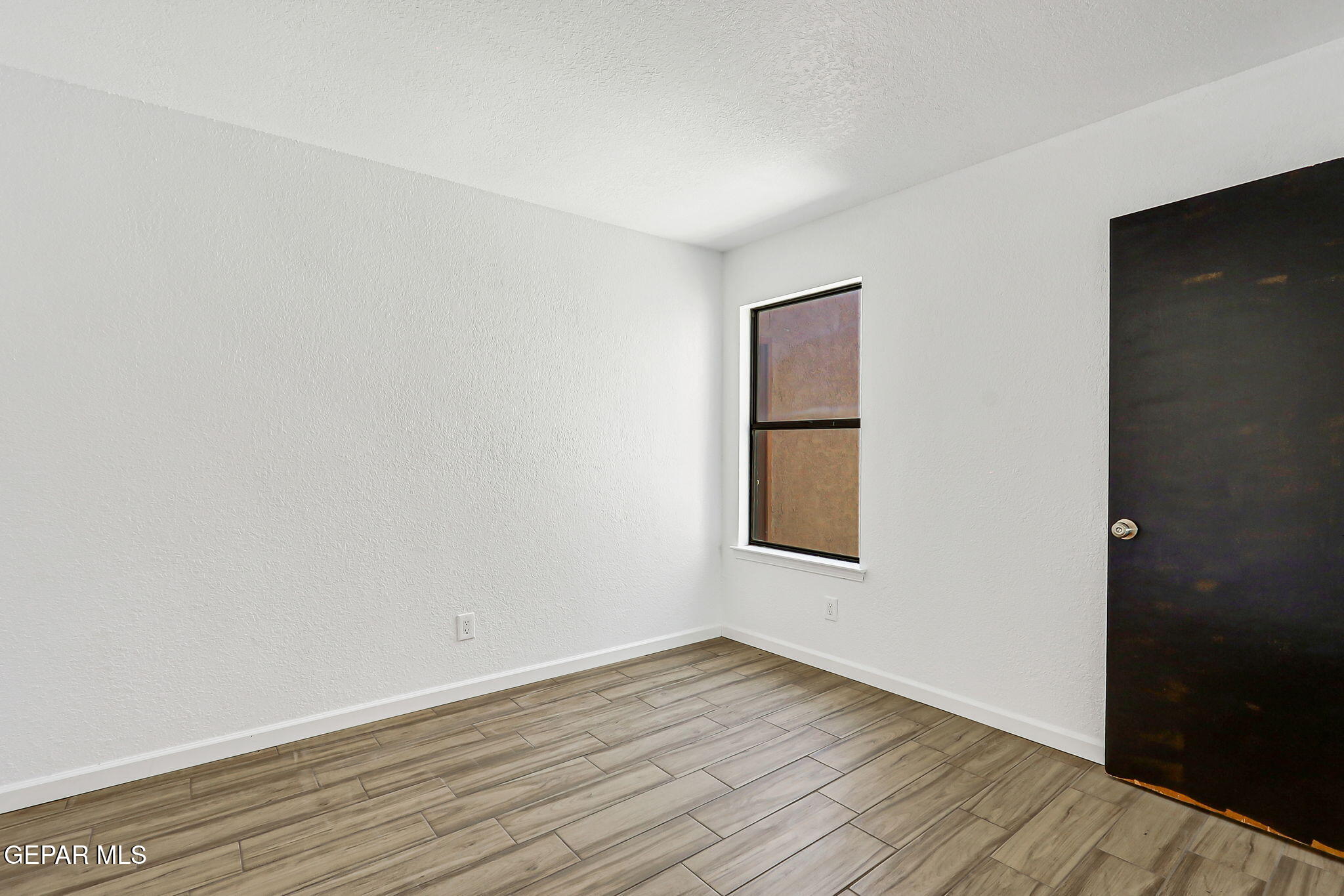 1053 Hillrise Court Las Cruces, NM 88011 - Photo 44 of 53 an empty room with wooden floor and windows