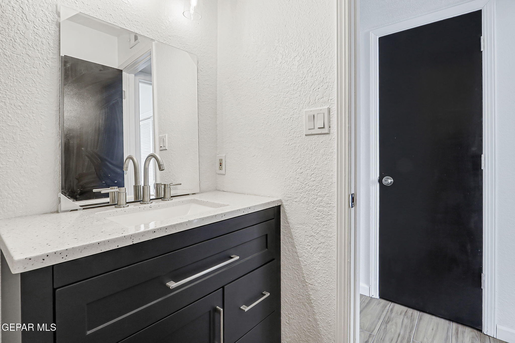 1053 Hillrise Court Las Cruces, NM 88011 - Photo 48 of 53 a bathroom with a granite countertop sink and a mirror