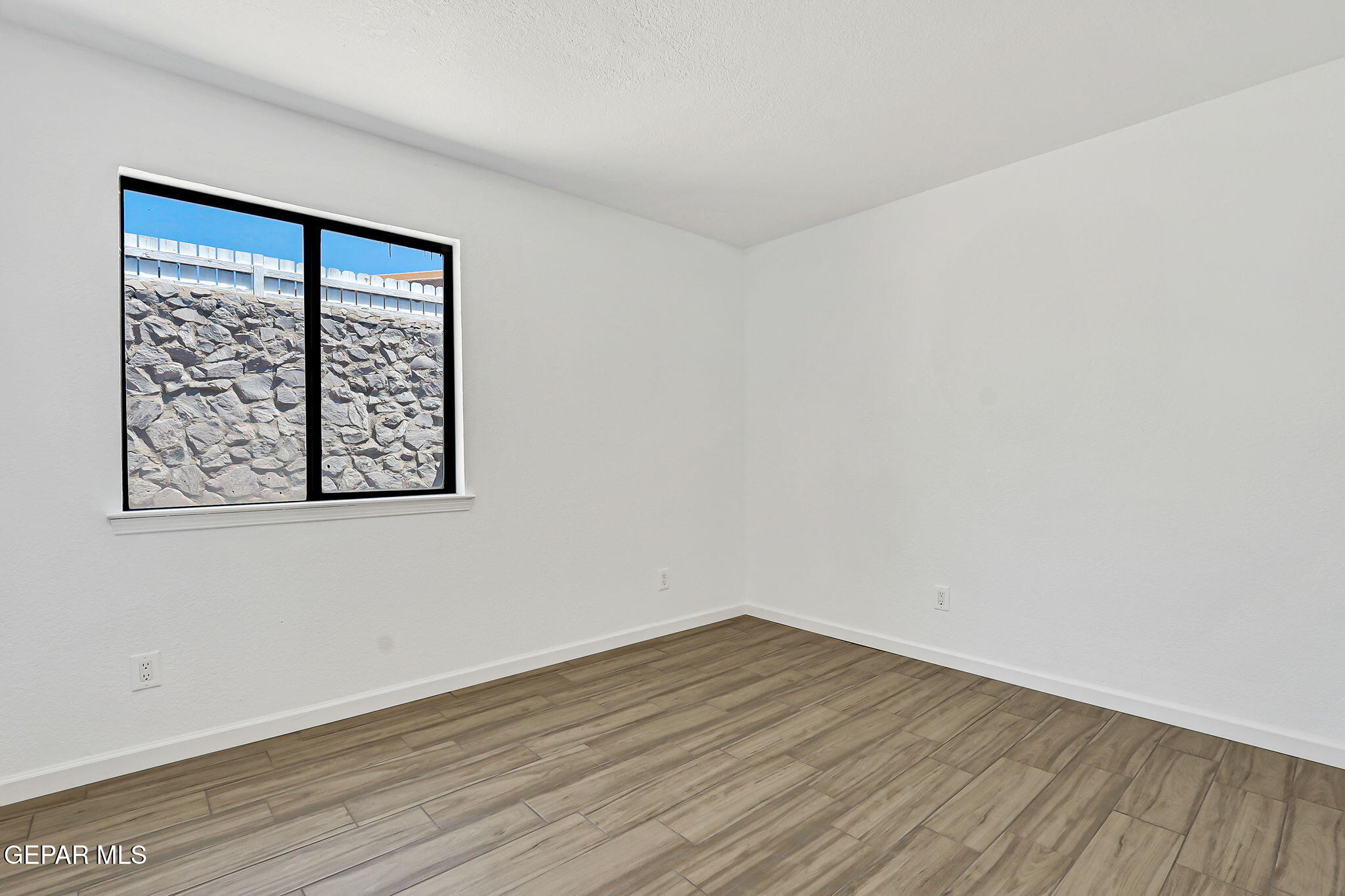 1053 Hillrise Court Las Cruces, NM 88011 - Photo 49 of 53 a view of an empty room with wooden floor and a window