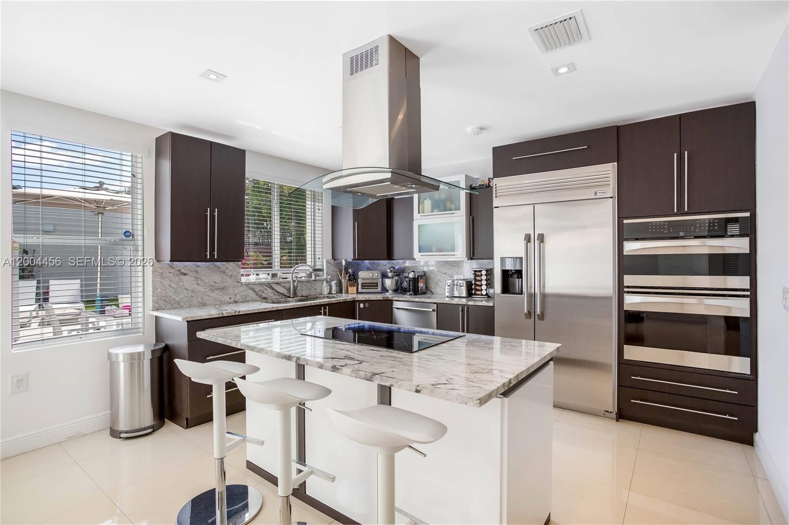 152 Southwest 20th Road Miami, FL 33129 - Photo 8 of 22 a kitchen with stainless steel appliances kitchen island granite countertop a sink and cabinets