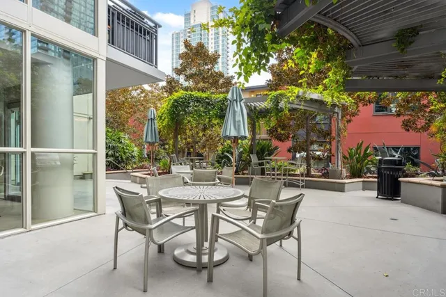 a view of a patio with couches table and chairs and potted plants