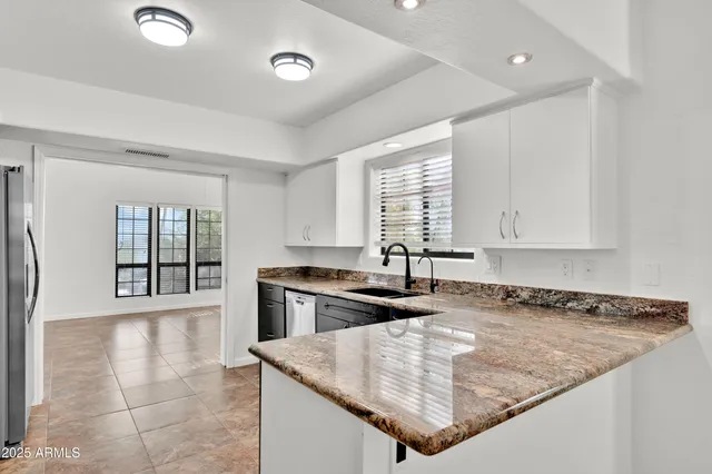a kitchen with granite countertop a sink and a stove
