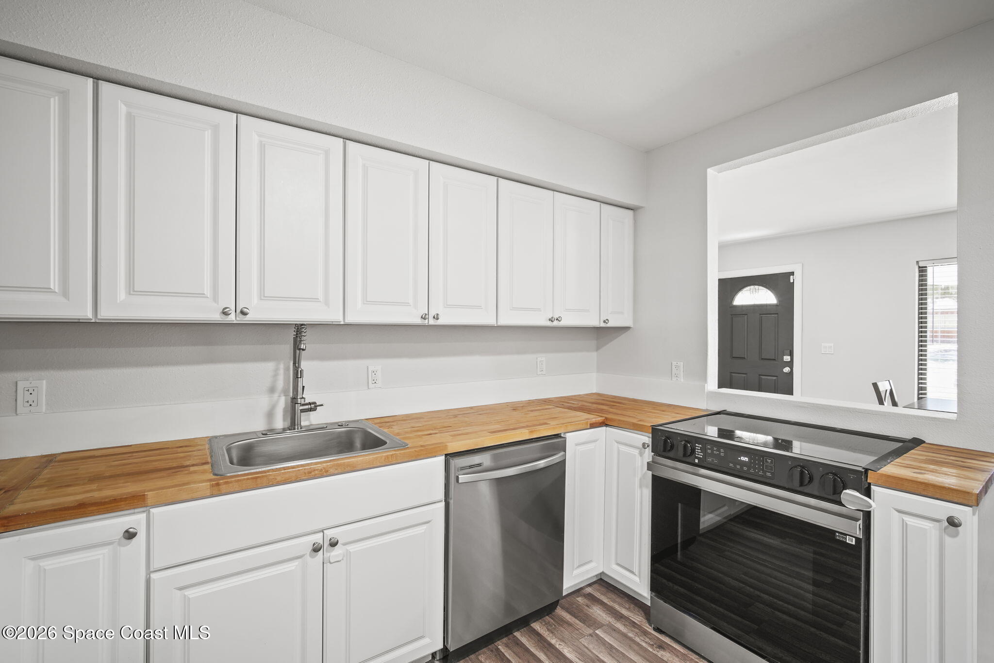 4665 Tuscarora Road Titusville, FL 32780 - Photo 11 of 34 a kitchen with granite countertop white cabinets and white appliances