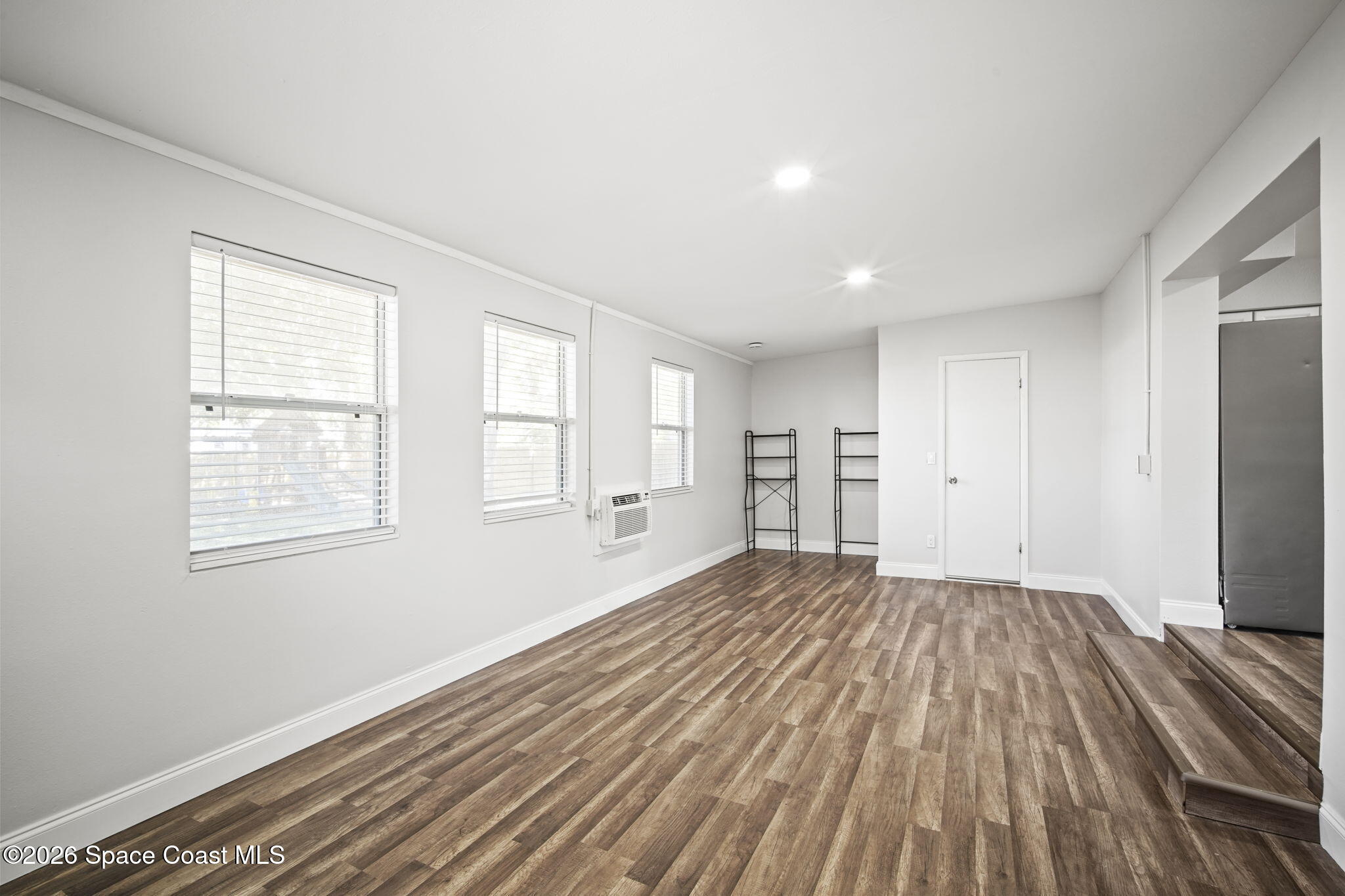 4665 Tuscarora Road Titusville, FL 32780 - Photo 12 of 34 wooden floor in an empty room with a window