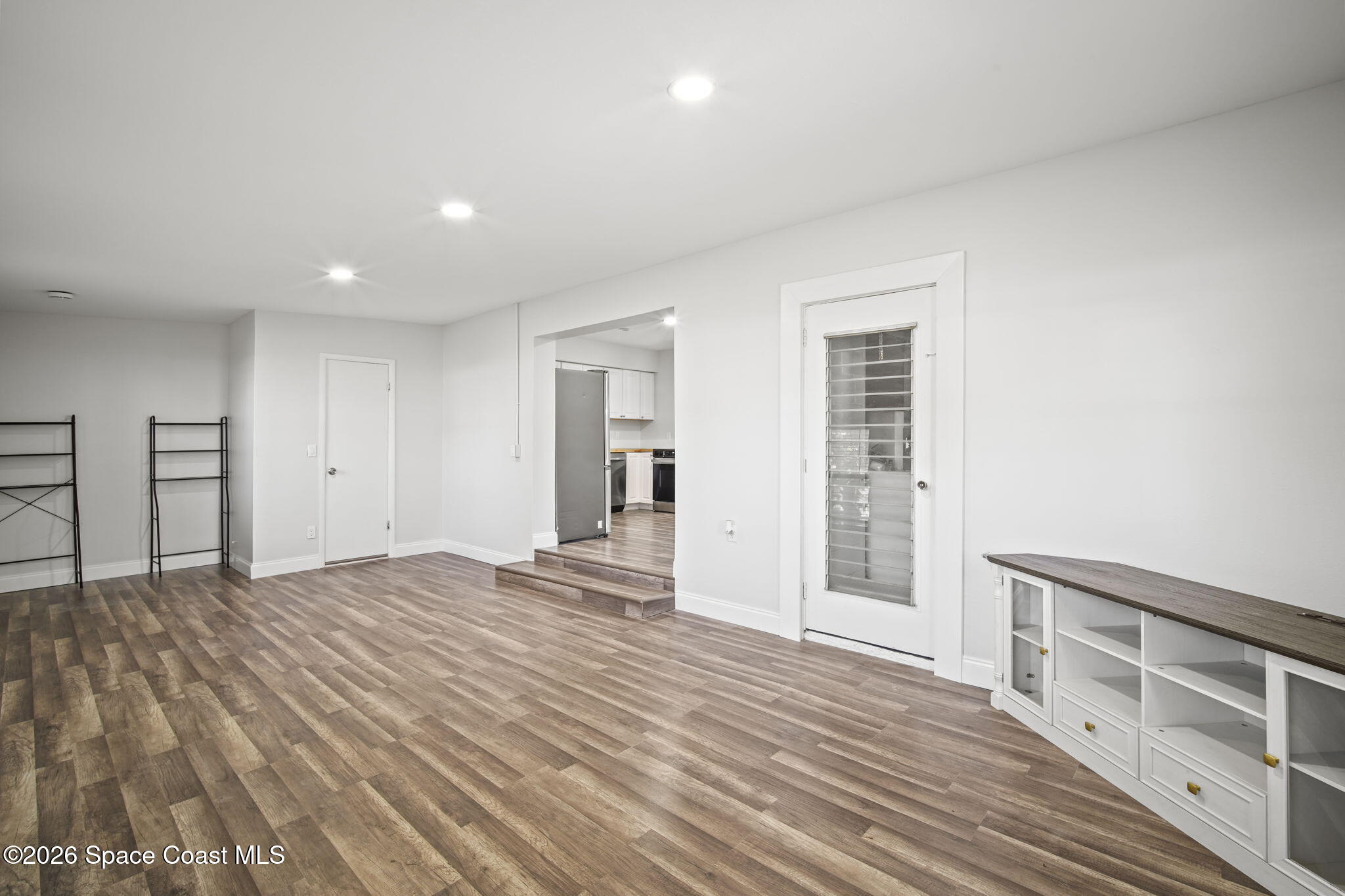 4665 Tuscarora Road Titusville, FL 32780 - Photo 13 of 34 a view of an empty room with wooden floor and a window