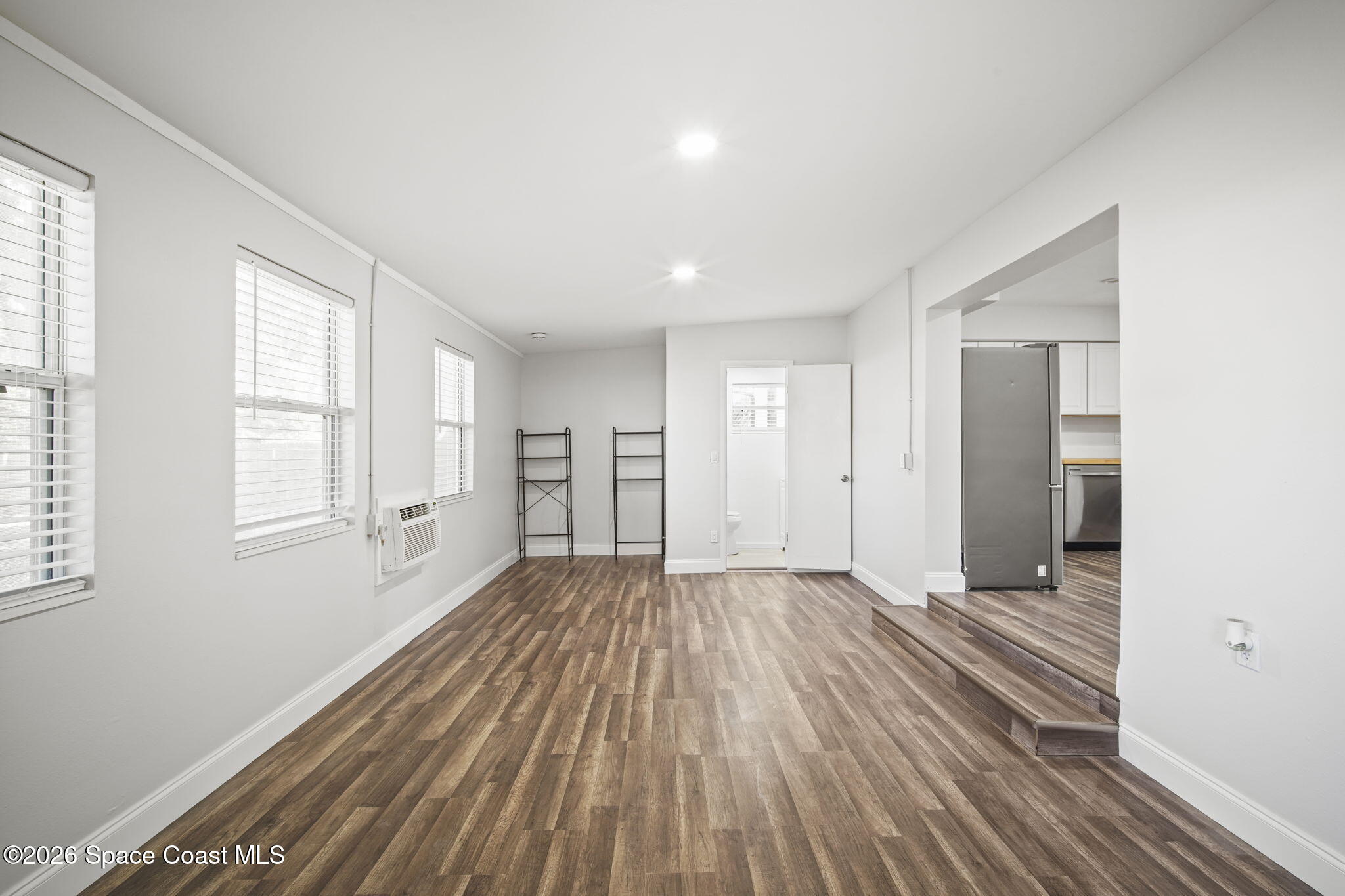 4665 Tuscarora Road Titusville, FL 32780 - Photo 14 of 34 a view of an empty room with wooden floor and a window