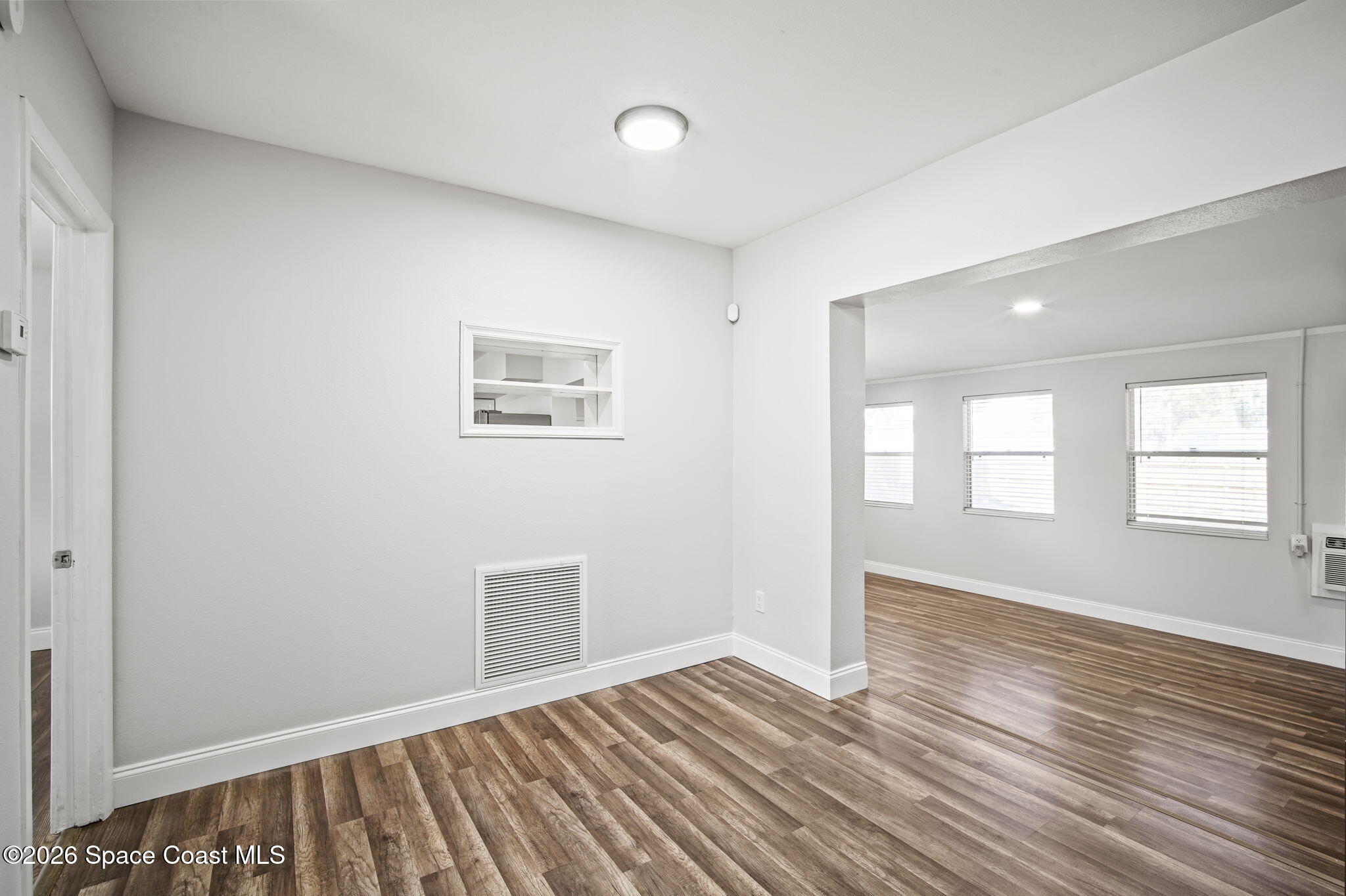 4665 Tuscarora Road Titusville, FL 32780 - Photo 18 of 34 a view of an empty room with wooden floor and a window